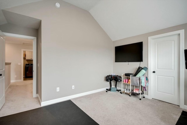 exercise room featuring light colored carpet and vaulted ceiling