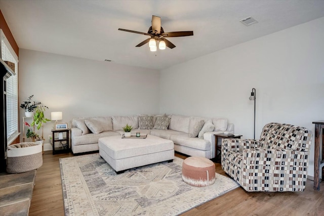 living room featuring wood-type flooring and ceiling fan