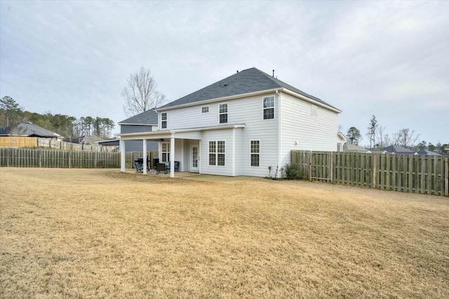 rear view of property with a patio and a lawn