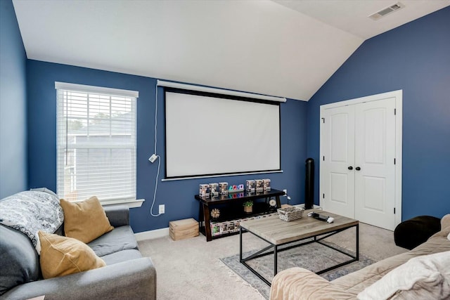 home theater featuring vaulted ceiling and light carpet