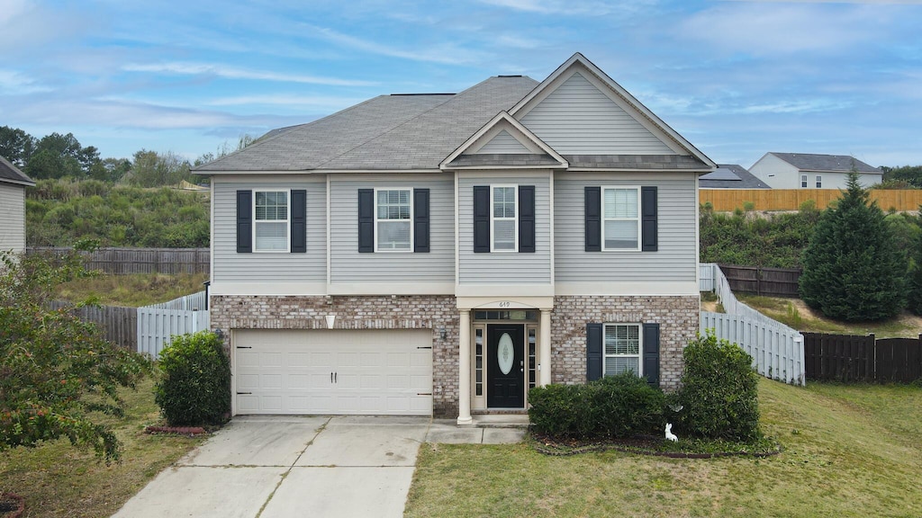 view of front of house with a garage and a front lawn