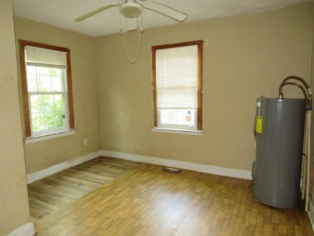 1466 Dewitt St, Augusta, GA 30901 - spare room with water heater, healthy amount of natural light, wood finished floors, and a ceiling fan