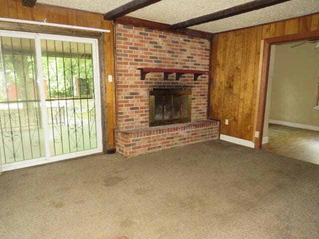 1466 Dewitt St, Augusta, GA 30901 - unfurnished living room with wooden walls, carpet, beam ceiling, and a fireplace
