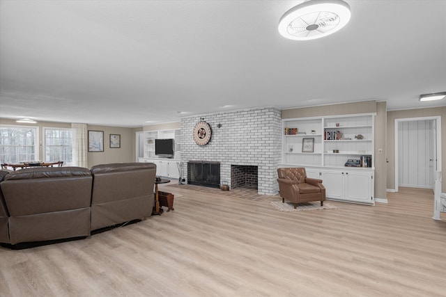 living room featuring a brick fireplace and light wood-type flooring