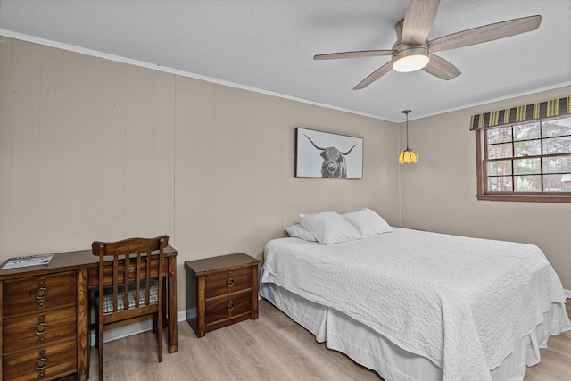 bedroom with crown molding, ceiling fan, and light wood-type flooring