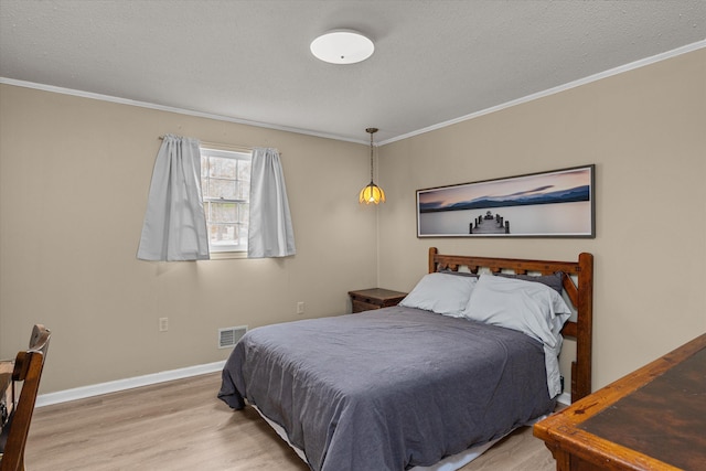 bedroom with crown molding, a textured ceiling, and light wood-type flooring