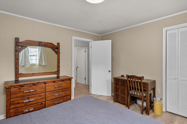 bedroom featuring ornamental molding, light wood-type flooring, and a closet