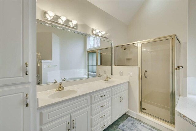 bathroom featuring tile patterned flooring, shower with separate bathtub, vanity, and vaulted ceiling