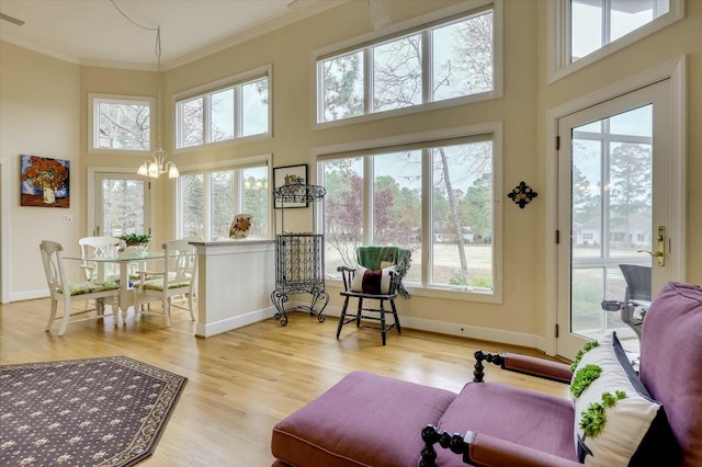 sunroom featuring a notable chandelier and a healthy amount of sunlight