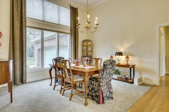 dining room featuring wood-type flooring, ornamental molding, and a chandelier