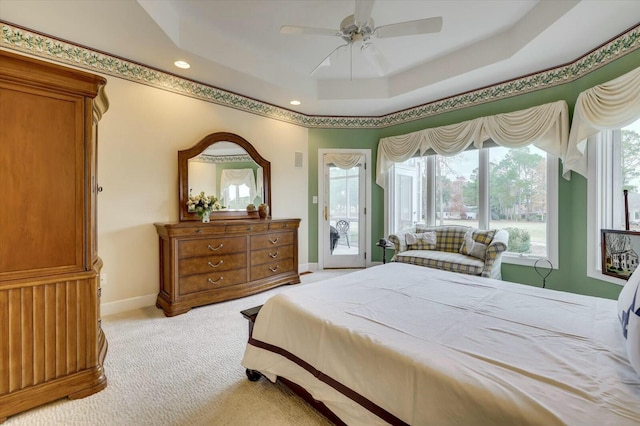 bedroom featuring a tray ceiling, access to exterior, ceiling fan, and light carpet