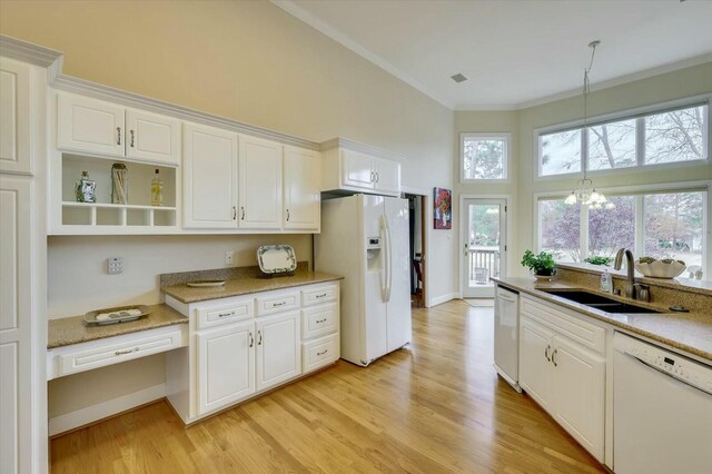 kitchen featuring white appliances, sink, light hardwood / wood-style flooring, an inviting chandelier, and white cabinets