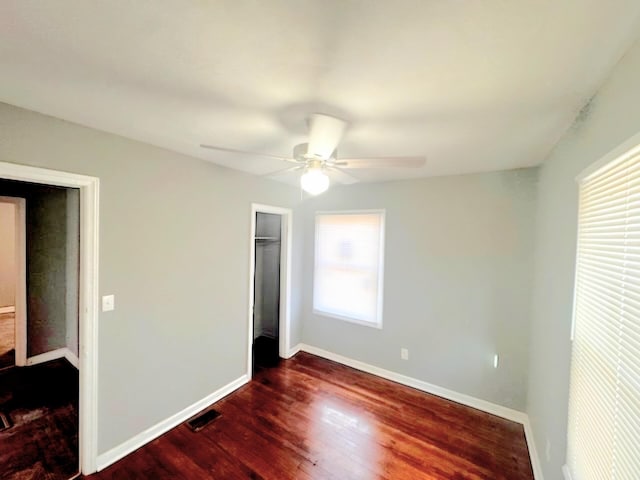 bedroom with dark hardwood / wood-style flooring, a closet, and ceiling fan