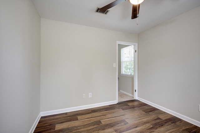 empty room with wood finished floors, a ceiling fan, and baseboards
