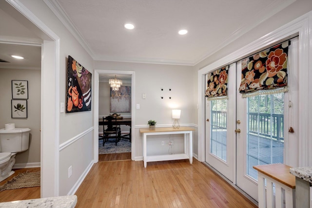 entryway featuring french doors, light wood-type flooring, a chandelier, ornamental molding, and recessed lighting
