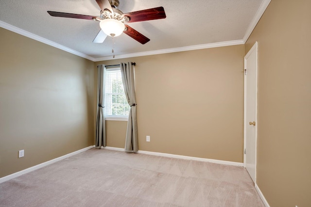 spare room with a ceiling fan, a textured ceiling, light carpet, ornamental molding, and baseboards