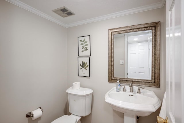 bathroom featuring a sink, ornamental molding, and toilet