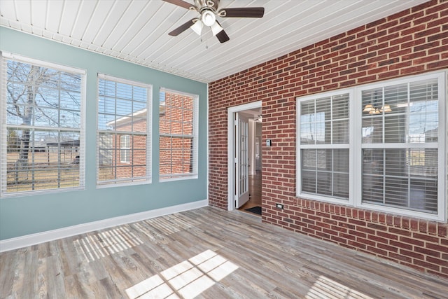 unfurnished sunroom featuring ceiling fan