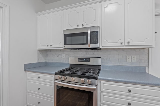 kitchen with stainless steel appliances, decorative backsplash, and white cabinets