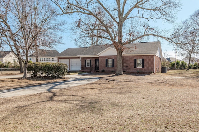 ranch-style home with a garage and central air condition unit