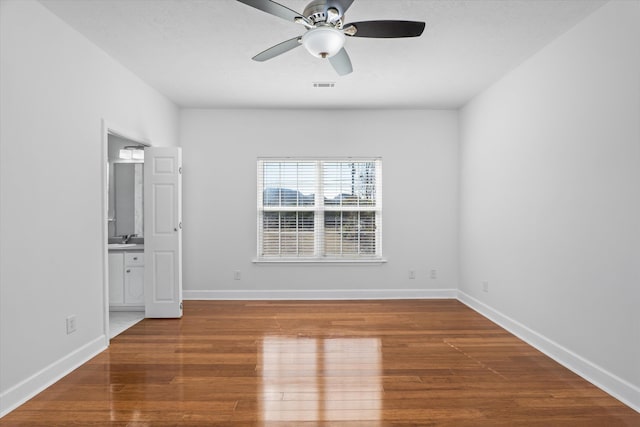 spare room featuring ceiling fan, wood-type flooring, and sink