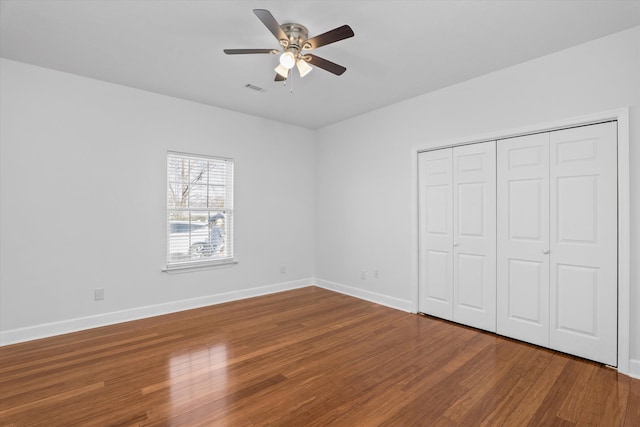 unfurnished bedroom with hardwood / wood-style flooring, ceiling fan, and a closet