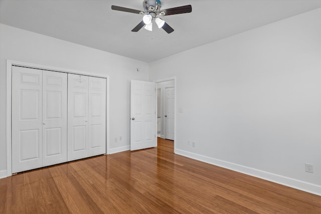 unfurnished bedroom with hardwood / wood-style floors, a closet, and ceiling fan