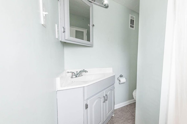 bathroom with tile patterned flooring, vanity, and toilet