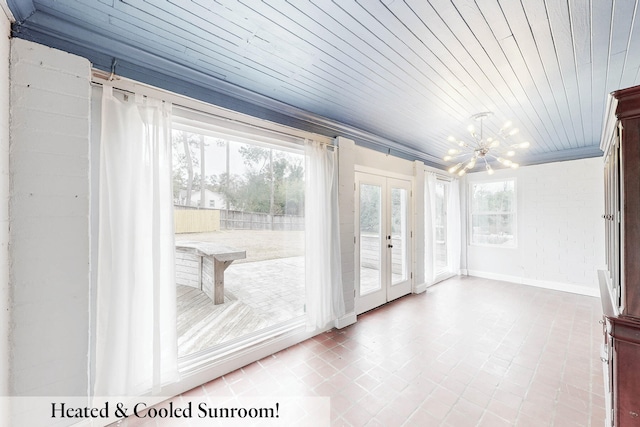 unfurnished sunroom featuring an inviting chandelier, french doors, and wooden ceiling