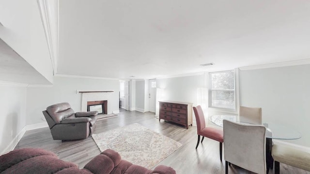 living room featuring wood-type flooring and crown molding