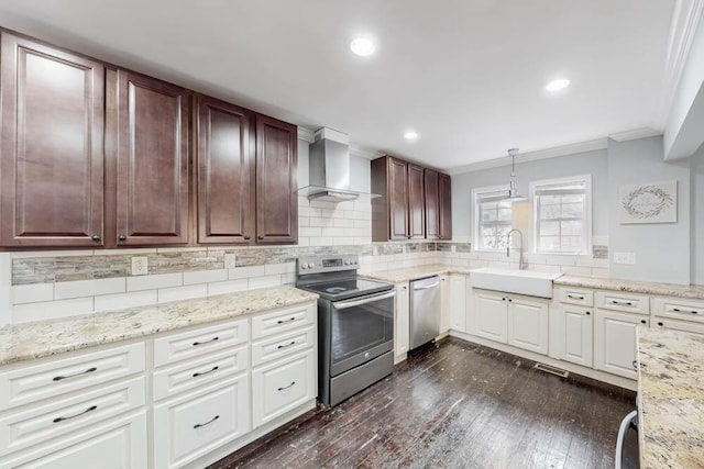 kitchen with sink, hanging light fixtures, stainless steel appliances, crown molding, and wall chimney range hood