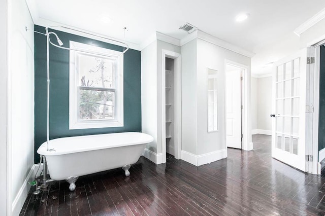 bathroom featuring ornamental molding, wood-type flooring, and a tub