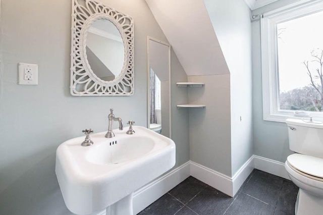 bathroom featuring lofted ceiling, sink, tile patterned floors, and toilet