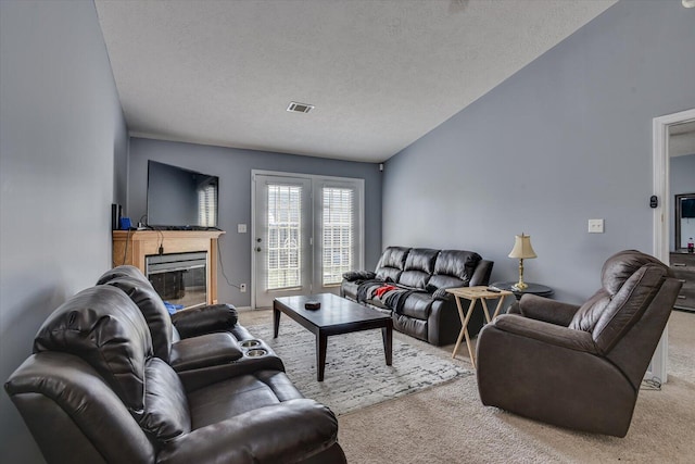 carpeted living room with a textured ceiling and vaulted ceiling