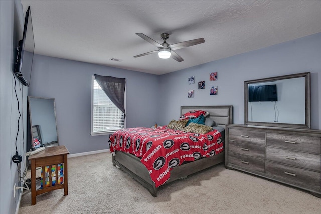 carpeted bedroom with a textured ceiling and ceiling fan