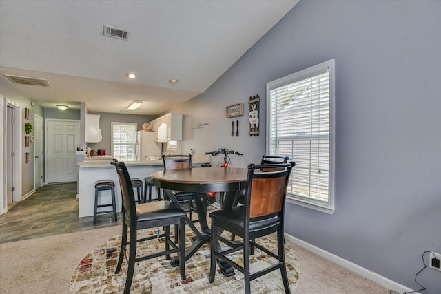 dining space with carpet floors and lofted ceiling