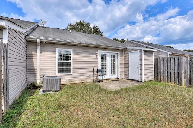 back of property with cooling unit and a lawn