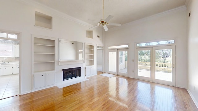 4154 Bent Tree Ln, Martinez, GA 30907 - unfurnished living room with crown molding, healthy amount of natural light, a fireplace with flush hearth, a sink, and a towering ceiling