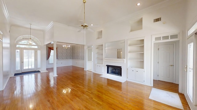 4154 Bent Tree Ln, Martinez, GA 30907 - unfurnished living room featuring a chandelier, crown molding, ceiling fan, built in shelves, and light wood-style flooring