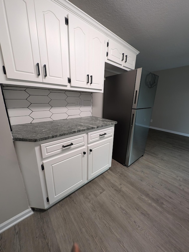 4331 Big Dipper Cir, Hephzibah, GA 30815 - kitchen with freestanding refrigerator, dark wood-type flooring, white cabinetry, backsplash, and a textured ceiling