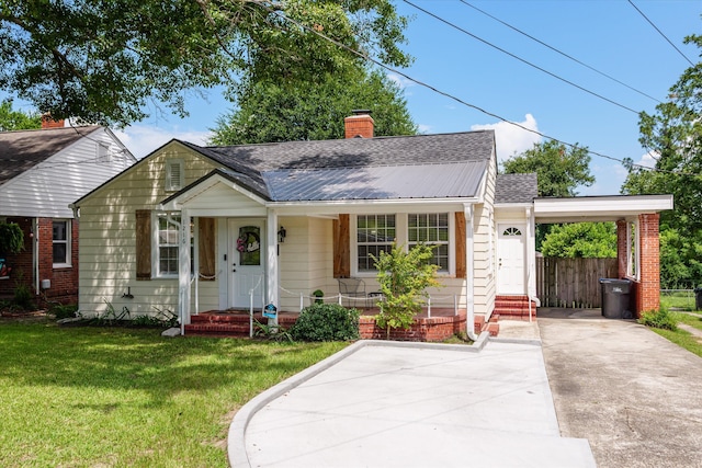 1216 Heard Ave, Augusta, GA 30904 - bungalow-style house featuring concrete driveway, a carport, a front yard, roof with shingles, and a metal roof
