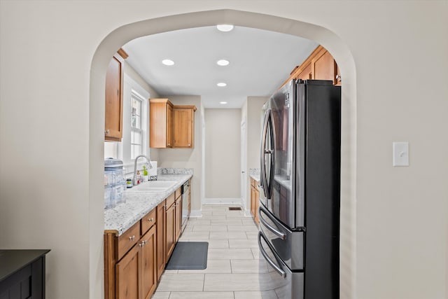 1216 Heard Ave, Augusta, GA 30904 - kitchen with stainless steel appliances, arched walkways, recessed lighting, light tile patterned floors, and brown cabinetry