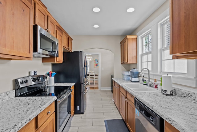 1216 Heard Ave, Augusta, GA 30904 - kitchen with stainless steel appliances, arched walkways, recessed lighting, light tile patterned floors, and brown cabinets