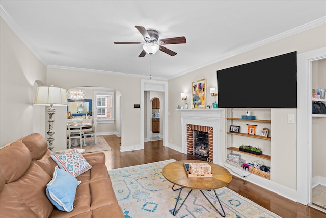 1216 Heard Ave, Augusta, GA 30904 - living room featuring arched walkways, ceiling fan, ornamental molding, wood finished floors, and a brick fireplace