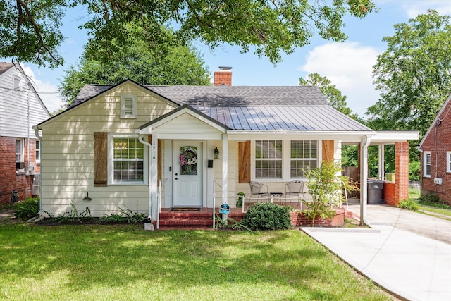 1216 Heard Ave, Augusta, GA 30904 - bungalow-style house featuring a chimney, a front lawn, a shingled roof, driveway, and a metal roof