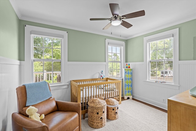 1216 Heard Ave, Augusta, GA 30904 - bedroom featuring wainscoting, a crib, wood finished floors, crown molding, and a ceiling fan