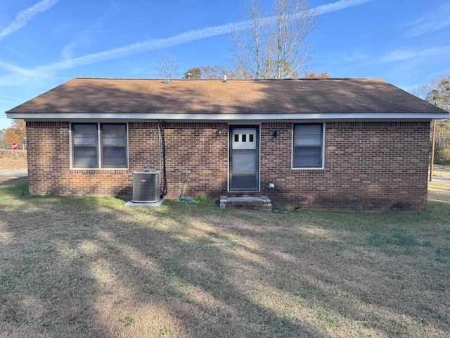 ranch-style house with a front yard and central AC