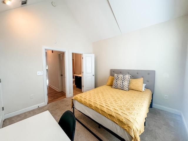 carpeted bedroom featuring high vaulted ceiling