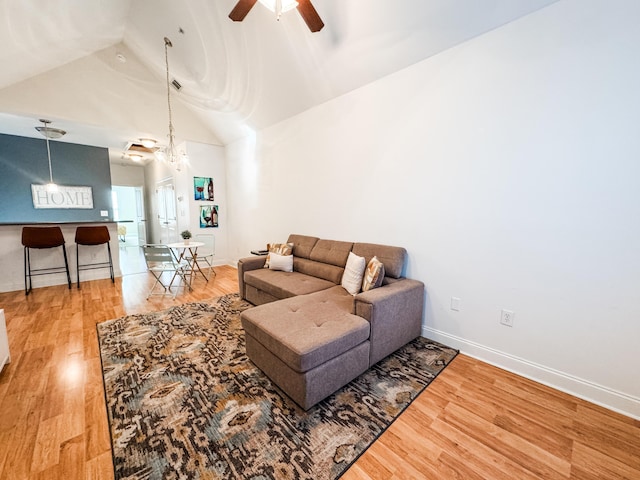 living room featuring hardwood / wood-style floors, ceiling fan, and lofted ceiling