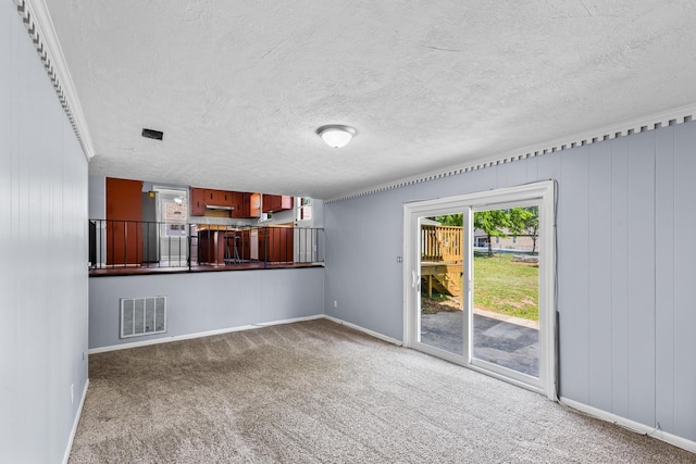 unfurnished living room featuring carpet flooring, visible vents, baseboards, and a textured ceiling